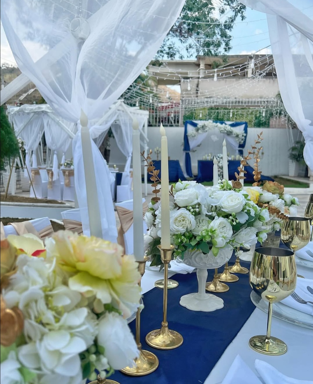 Salón de bodas de lujo con arreglos florales grandes y luces cálidas