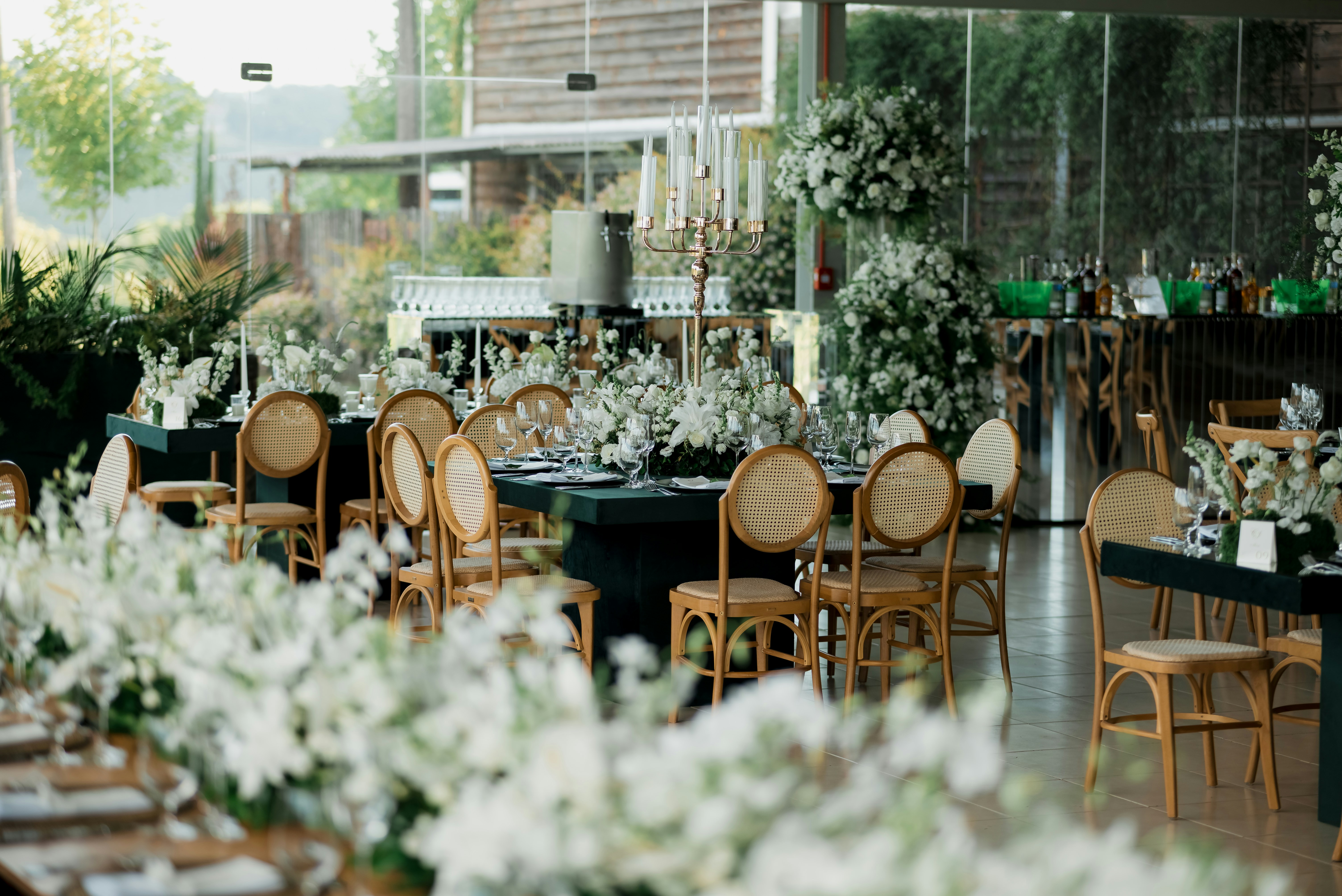Decoración de lujo para boda de gala en exteriores bajo una elegante pérgola de madera con lámpara de cristal